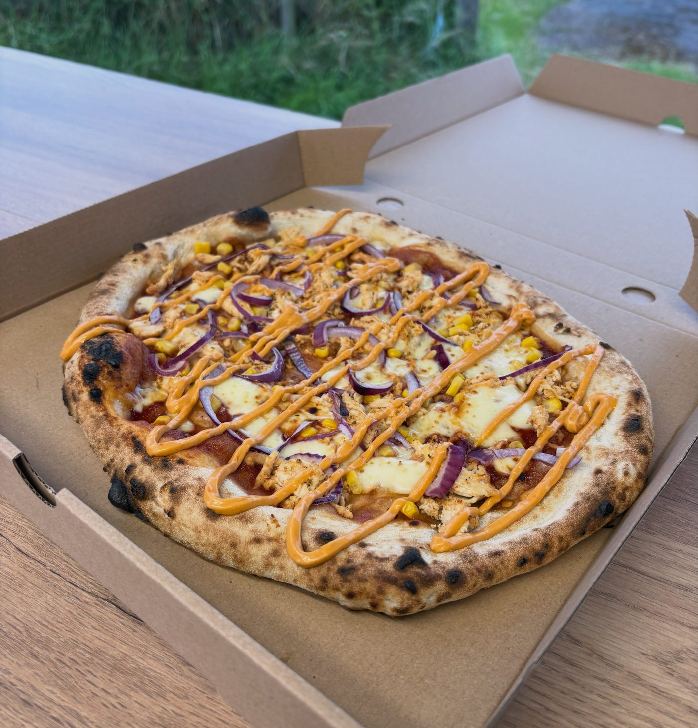 Stonebaked pizza topped with chicken, sweetcorn, red onion and chipotle mayo drizzle