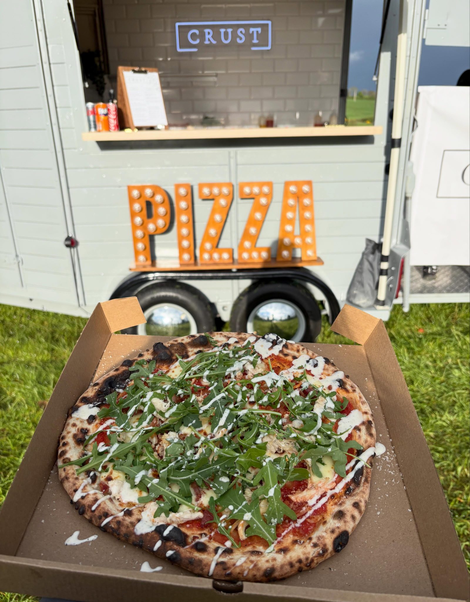 Freshly boxed pizza in front of the Crust trailer